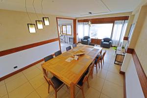 Un comedor con mesa y sillas de madera. en Departamento 4 dormitorios - Roca 1, en Ushuaia