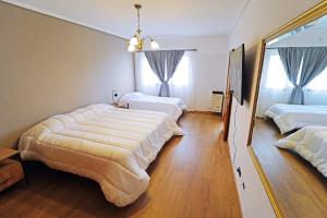 1 dormitorio con 3 camas y un espejo grande en Departamento 4 dormitorios - Roca 1, en Ushuaia
