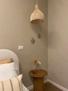 a bedroom with a bed and a table with a lamp at Dimora Alberto in Lucca +2 photos