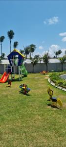 a park with a playground with toys on the grass at Porto Alto in Ipojuca