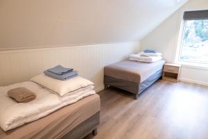 two twin beds in a room with a window at Gammelbanken Seaview Suites - Modern Apartments with Sea View, Lofoten in Ballstad