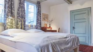 a bedroom with a white bed with a blue door at Klosterkrug Apartments in Lüneburg