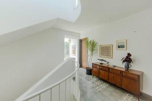 a white room with a staircase and a wooden cabinet at Presidential Luxury Villa Anjuna with Private Pool and Dedicated Caretaker in Old Goa +17 photos