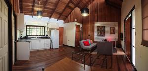 a kitchen and living room with a table and chairs at Casa Arthémis - Rainforest Lodge in Guápiles