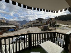 a balcony with a chair and a view of a town at Studio cabine rénové, 4 couchages, pied des pistes, parking, balcon sud - FR-1-297-160 in Auris +5 photos