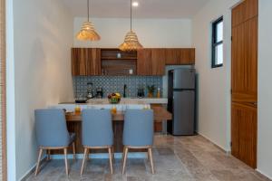 a kitchen with a table and chairs and a refrigerator at New luxury studio with plunge pool in Tulum