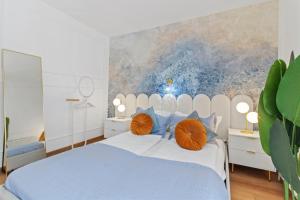 a bedroom with a large white bed with orange pillows at Art Hotel Vienna in Vienna