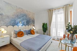 a bedroom with a large white bed with orange pillows at Art Hotel Vienna in Vienna