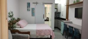 a small room with a bed and a kitchen at Amarílis Riviera-Estúdio A-209 in Bertioga