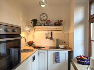 a kitchen with a sink and a clock on the wall at Vintage-Wohnung Silberstadt in Freiberg