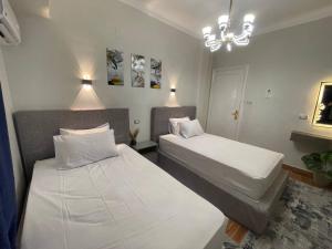 a bedroom with two beds and a chandelier at Nadasha guest house cairo view in Cairo