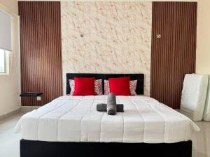 a bedroom with a large bed with red pillows at De Home Desaru Luxury Suite Near Beach 3Pax D13A05 in Bandar Penawar