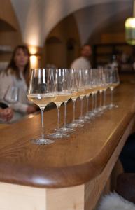 a row of wine glasses sitting on a bar at Landhotel Hirsch in Kempten +21 photos