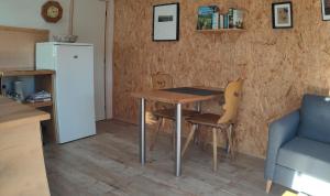 a kitchen with a table and chairs and a refrigerator at Chalet Notcimick in Raon-sur-Plaine