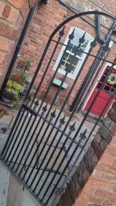 a black metal gate in front of a brick building at Lower Hollin- Suite with countryside views within a private home in Rock