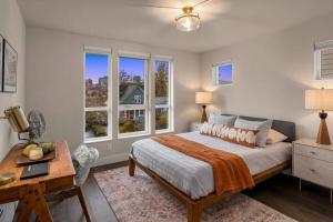 a bedroom with a bed and a desk and windows at New House in peaceful and trendy Central District in Seattle