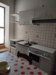 cocina con fregadero y mesa con mantel en Mare Azzurro, en Locri