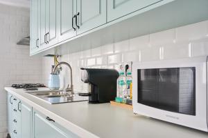 una cucina bianca con forno a microonde e lavandino di VintageHouse a Campo Maior