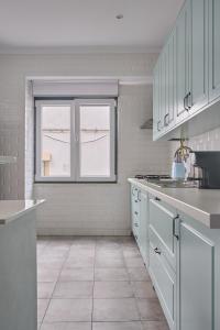 una cucina con mobili bianchi e una finestra di VintageHouse a Campo Maior