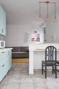 una cucina con bancone bianco e sedia nera di VintageHouse a Campo Maior Altre 18 foto