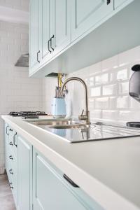 una cucina con mobili bianchi e un lavandino di VintageHouse a Campo Maior