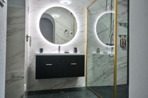 a bathroom with two mirrors and a sink at NatureHouse in Campo Maior