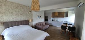 a bedroom with a bed and a couch and a kitchen at Paraíso Azul in Eira do Chão