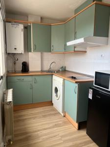 a kitchen with green cabinets and a washing machine at Las cerezas in Ciudad Real