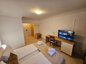 a room with a television and a desk with a chair at Hotel Royal Plaza in Timişoara