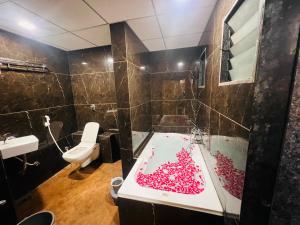 a bathroom with a tub filled with pink jelly beans at Hotel secure inn kadodara road in Surat +14 photos
