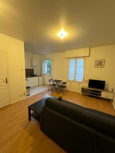 a living room with a couch and a table at Studio idéal Gare & Centre-Ville in Conflans-Sainte-Honorine