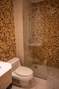 a bathroom with a toilet and a glass shower at أبحر ريزيدينس804 in Obhor +35 photos