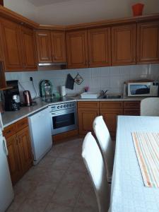 una cucina con armadi in legno e un piano cottura bianco con forno di Mézeskalács vendégház a Balatonboglár Altre 8 foto