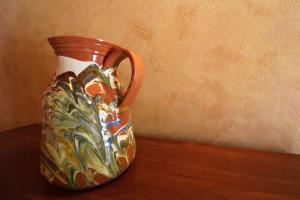 a colorful vase sitting on top of a table at Casa del Río by SIERRA VIVA in La Nava +3 photos