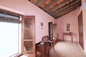 a room with a table and a chair and a window at Casa del Río by SIERRA VIVA in La Nava