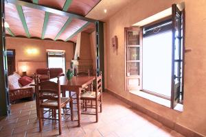 a dining room with a table and chairs and a window at Casa del Río by SIERRA VIVA in La Nava