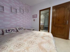 a bedroom with a large bed and a wooden door at La Casa de Juan in Jarandilla de la Vera