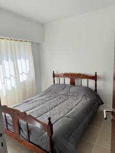 a wooden bed in a bedroom with a window at La Mary in Mar del Plata