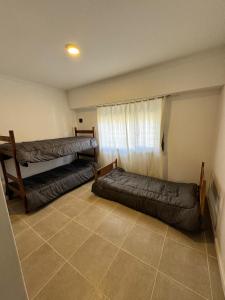 a living room with two beds and a window at La Mary in Mar del Plata