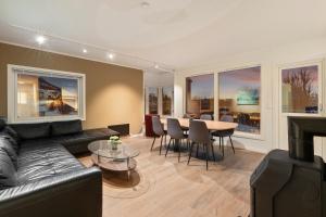 a living room with a black couch and a table at Arctic Aurora Apartment I SAUNA I Family & Groups in Tromsø