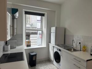 a kitchen with a washing machine and a window at Cook street accommodation in Cork