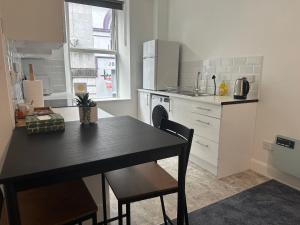 a kitchen with a black table and a kitchen counters at Cook street accommodation in Cork