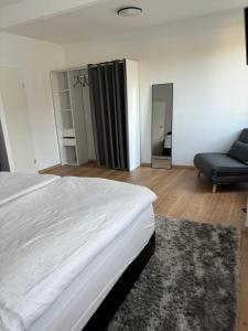 a bedroom with a bed and a chair and a mirror at Am Pferdestall in Gräfenhainichen