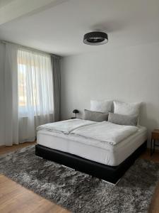 a bedroom with a large white bed with a rug at Am Pferdestall in Gräfenhainichen