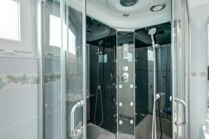 a shower with glass doors in a bathroom at Apartments Coli app Afrodita & Antonia & Veronika in Bakar +105 photos