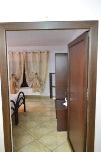 Pensiunea Lui Nea Nicu Lepsa في ليبسا: غرفة بها باب ونافذة بها ستائر +صورتان