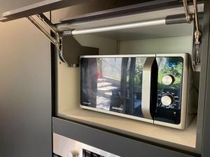 a microwave sitting on a shelf in a kitchen at Amelie - petite maison alsacienne in Blotzheim