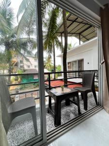 a balcony with a table and a chair on a patio at V R Holiday Home in Candolim