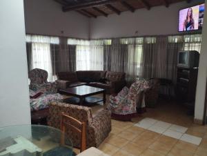 a living room with couches and a table and a tv at santa cecilia in La Vega