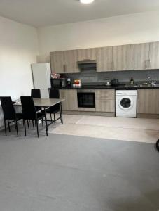 a kitchen with a table and chairs and a washing machine at Barnsley Guesthouse in Barnsley